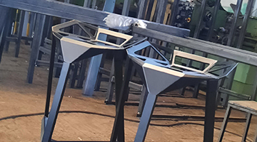 mężczyzna spawa element stalowy